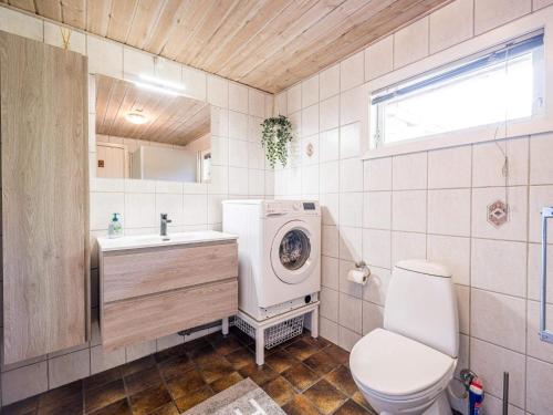 a bathroom with a toilet and a sink and a washing machine at Holiday home Blåvand CCXXXVIII in Blåvand