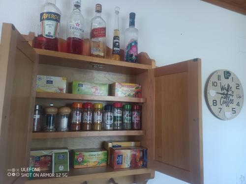 a cabinet filled with lots of drinks and a clock at Haldi Apartment in Klosters Serneus