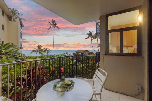 a balcony with a table and a view of the ocean at Noelani 111 in Kahana