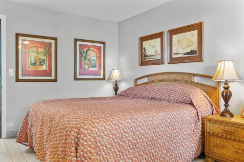a bedroom with a bed and three pictures on the wall at Noelani 111 in Kahana