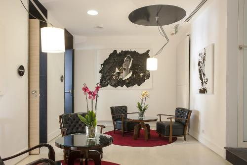 a waiting room with chairs and a table and a table and chairs at Hotel Nord Nuova Roma in Rome