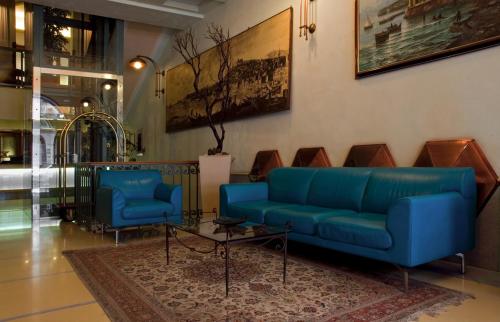 a lobby with two blue couches and a table at Hotel Eden in Naples