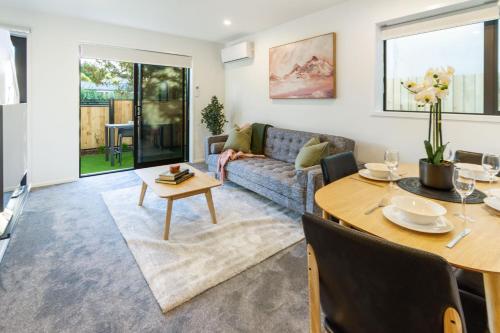 a living room with a couch and a dining room table at Best of Central Christchurch 2 bed 2 bath in Christchurch