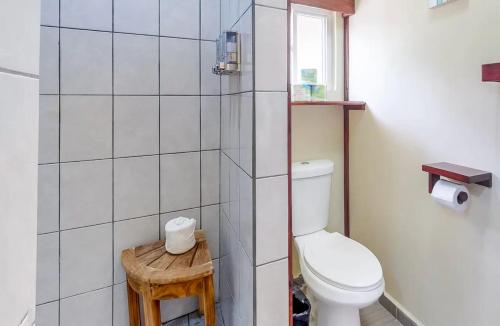 a small bathroom with a toilet and a window at Sandy Feet Beach Resort in Placencia Village