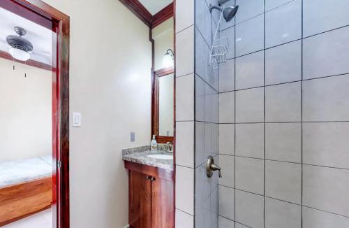 a bathroom with a shower and a sink at Sandy Feet Beach Resort in Placencia Village