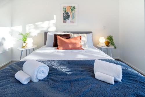 a bedroom with a large bed with towels on it at Best of Central Christchurch 2 bed 2 bath in Christchurch