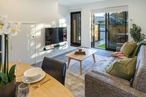 a living room with a couch and a table at Best of Central Christchurch 2 bed 2 bath in Christchurch