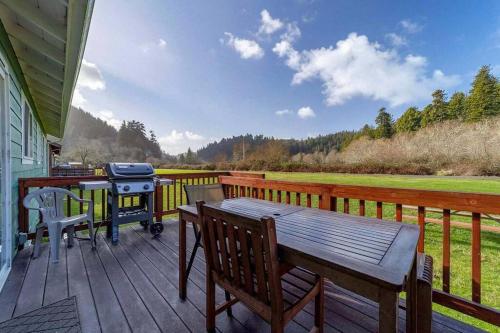 a wooden deck with a grill and a picnic table at Elk Meadow Cabins 17A Gold Rush Suite in Orick