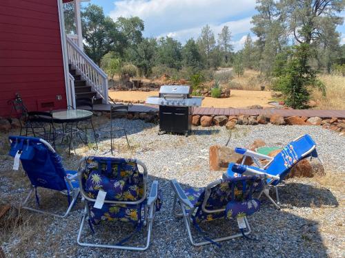 a group of chairs and a grill in a yard at Bear Creek Falls Lodge on 67 acres Creek & Waterfalls in Millville