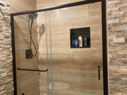 a shower in a bathroom with a glass door at Bear Creek Falls Lodge on 67 acres Creek & Waterfalls in Millville