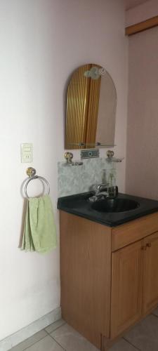 uma casa de banho com um lavatório e um espelho em La Casa de la Abuela en Puebla em San Baltasar