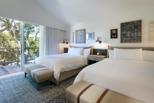 a bedroom with two beds and a large window at Carmel Valley Ranch, in The Unbound Collection by Hyatt in Carmel Valley
