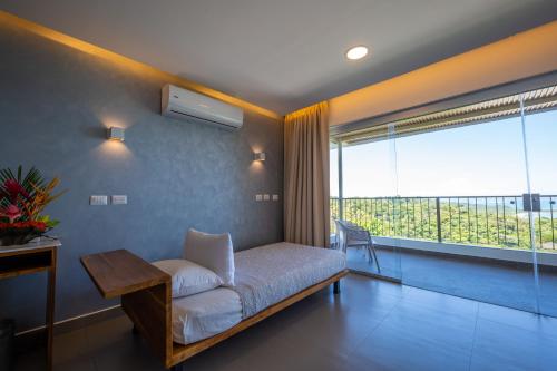 a bedroom with a bed and a large window at Hotel La Mariposa in Manuel Antonio