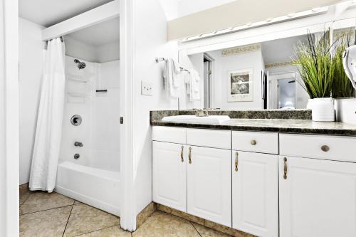 a white bathroom with a sink and a shower at Paki Maui 326 in Kahana