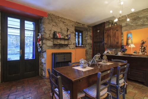 uma cozinha com uma mesa e cadeiras de madeira e uma lareira em B&B Melizio em San Maurizio dʼOpaglio