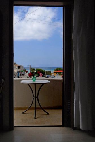 a room with a table and a view of a balcony at Pension Kyriakos in Plakias