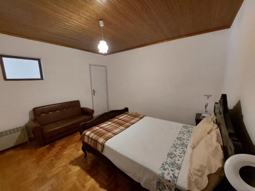 a bedroom with a bed and a couch in it at Casa do Pisco in Sardoal