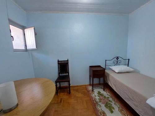 - une chambre avec un lit, une table et une chaise dans l'établissement Casa do Pisco, à Sardoal