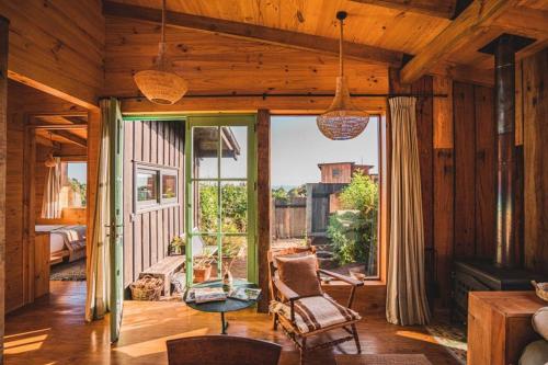 a room with a chair and a large window at Casita boutique con tina exterior in Pichilemu