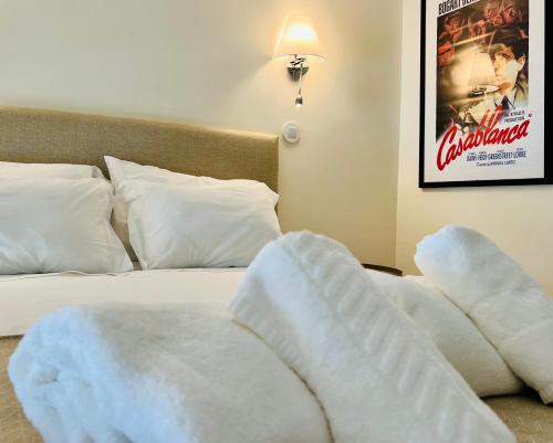 a bedroom with a bed with white sheets and a movie poster at ESTÚDIO 81 junto à Sinagoga in Tomar