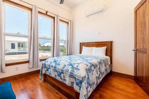 a bedroom with a bed and two windows at Closer to Heaven and The PoolClub at Mahogany Bay! in San Pedro