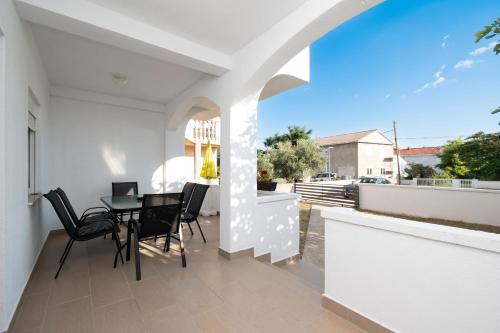 a dining room with a table and chairs on a balcony at Apartments with a parking space Povljana, Pag - 11516 in Povljana