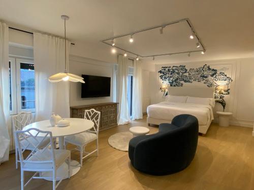 a bedroom with a white bed and a table and a room at Apartamentos BEJAR - INDIGO in Béjar