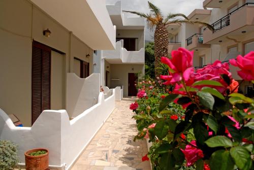 a courtyard of a building with pink flowers at Pension Kyriakos in Plakias