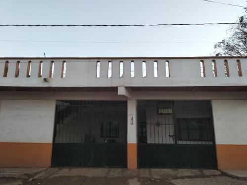 a building with a gate and a fence at Casa las cabras in La Peñita de Jaltemba