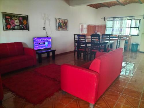 a living room with red furniture and a dining room at Casa las cabras in La Peñita de Jaltemba