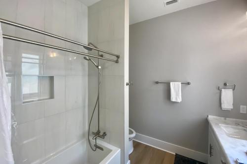 a white bathroom with a shower and a sink at Macon Memories in St. George Island