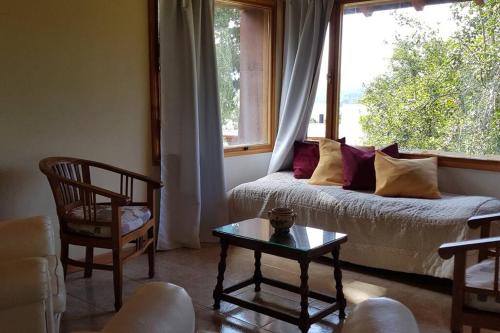 een woonkamer met een bank en een raam bij Casa de montaña con vistas al lago y a los cerros in Villa La Angostura