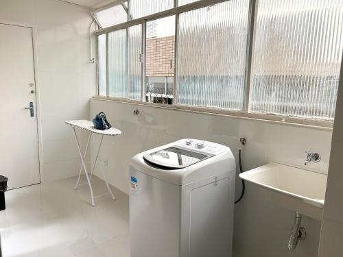 bagno bianco con lavatrice e lavandino di Apartamento em Belo Horizonte a Belo Horizonte