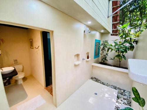 a bathroom with a sink and a toilet and a plant at Calala Lodge in Cabuya