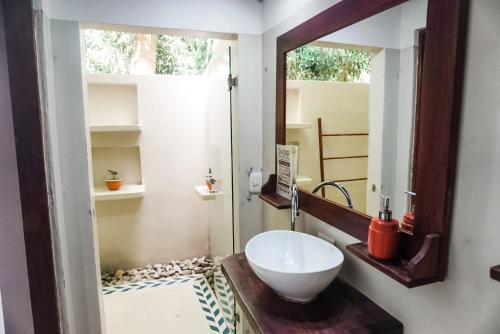 a bathroom with a bowl sink and a mirror at Calala Lodge in Cabuya
