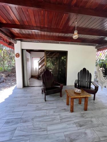 a patio with two chairs and a table at Calala Lodge in Cabuya