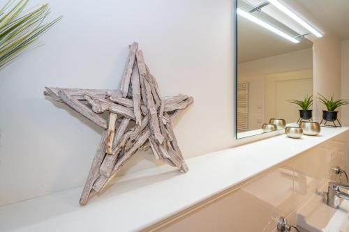 een houten zeester op een badkamerbar voor een spiegel bij Meersalz in Westerland