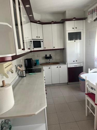a kitchen with white cabinets and a white counter top at Piso pineda in Monforte de Lemos
