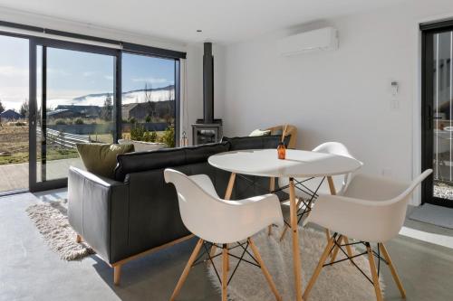 a living room with a couch and a table and chairs at Camp Cardrona Apartments in Cardrona