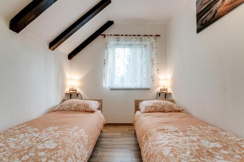 two beds in a room with a window at Holiday house with a parking space Fuzine, Gorski kotar - 20518 in Lokve