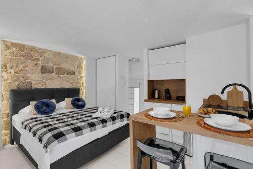 ein Schlafzimmer mit einem Bett und einer Theke mit einem Tisch in der Unterkunft Apartments by the sea Makarska - 21443 in Makarska