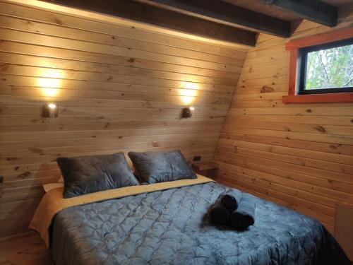 ein Schlafzimmer mit einem Bett in einem Blockhaus in der Unterkunft M Refugios, Termas de Chillán in Pinto