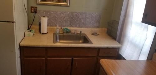 a kitchen counter with a sink and a refrigerator at ARMANI MANOR Rustic UNIT 2 in Wildwood