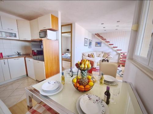 a kitchen with a table with a bowl of fruit on it at Apartments for families with children Solin, Split - 21472 in Solin