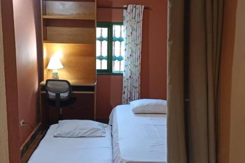 een slaapkamer met 2 bedden, een raam en een stoel bij Cabaña El Refugio in El Peñol