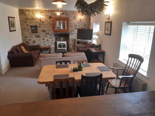 a living room with a table and chairs and a couch at The Mews, Talley in Llandeilo
