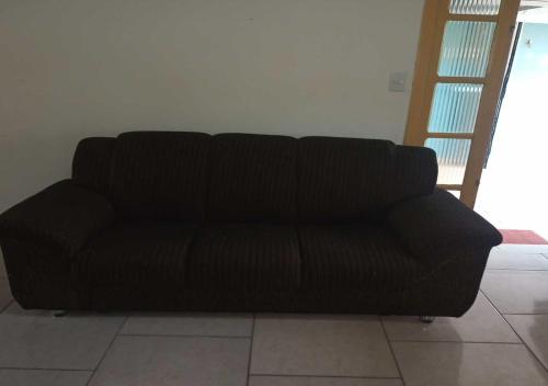 a black couch sitting in a living room at Lugar perfeito para você e sua família in Rio Grande