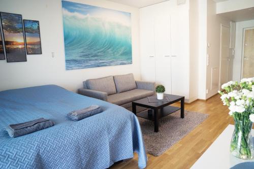 ein Schlafzimmer mit einem blauen Bett und einem Sofa in der Unterkunft Top location IICenter IIParking in Oulu
