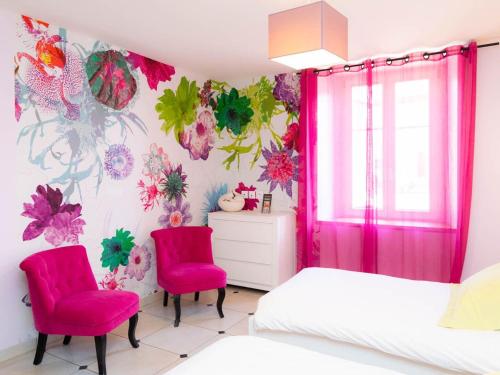 a bedroom with two beds and pink chairs at Gîte familial près de Nancy avec grand jardin, spa, salle de jeux, et équipements pêche - FR-1-584-15 in Laneuveville-devant-Bayon