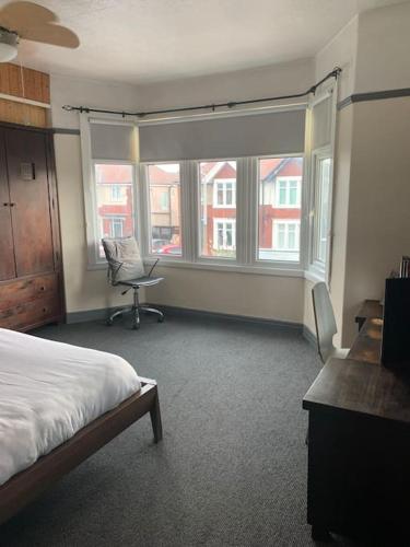 a bedroom with a bed and a chair and a window at Family Holiday Home in Blackpool